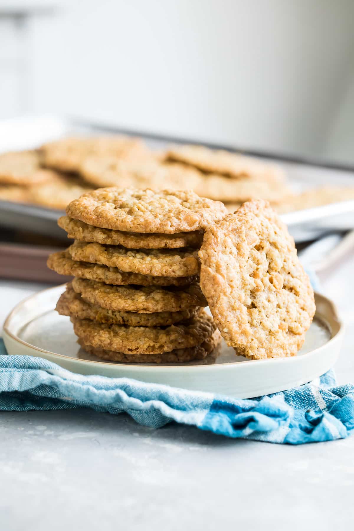Oatmeal scotchies stacked on a white plate.