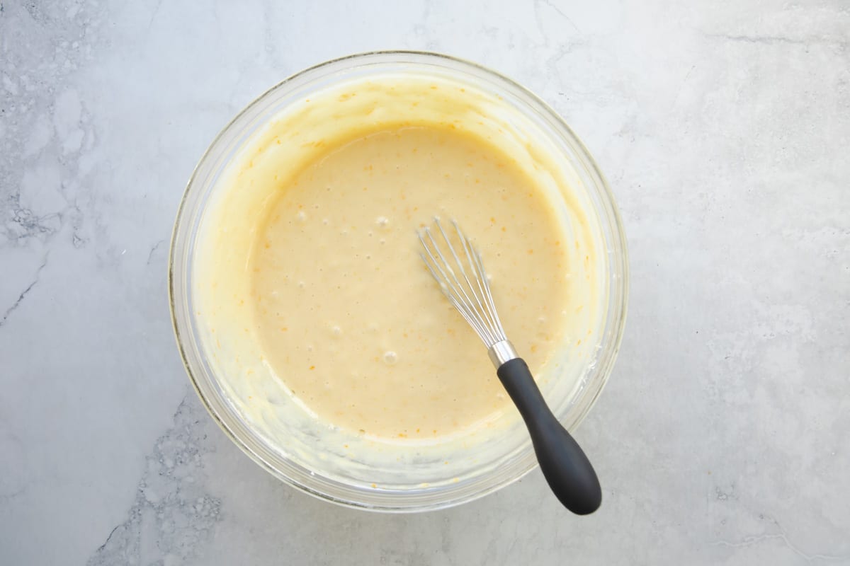 Orange cake batter in a mixing bowl.