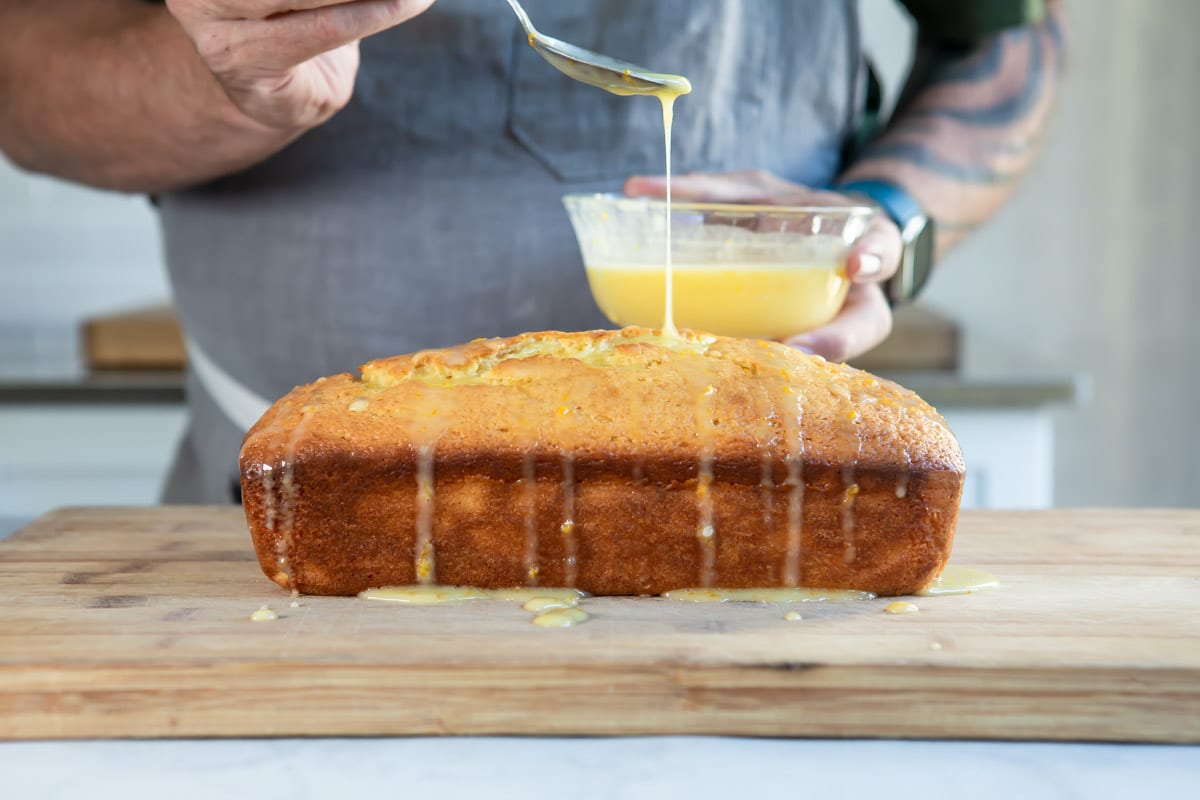 Drizzling glaze over an orange cake.
