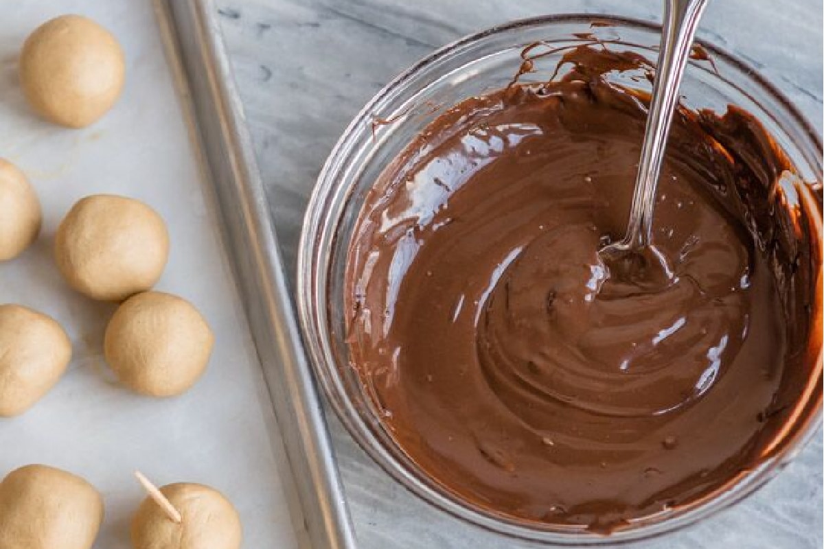 Dipping buckeyes in melted chocolate.