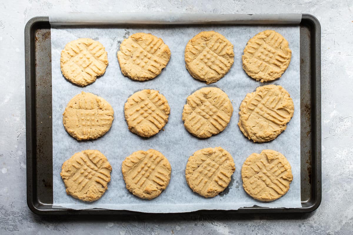 Baked peanut butter cookies on a baking sheet.