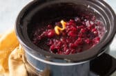 A slow cooker filled with cranberry sauce.