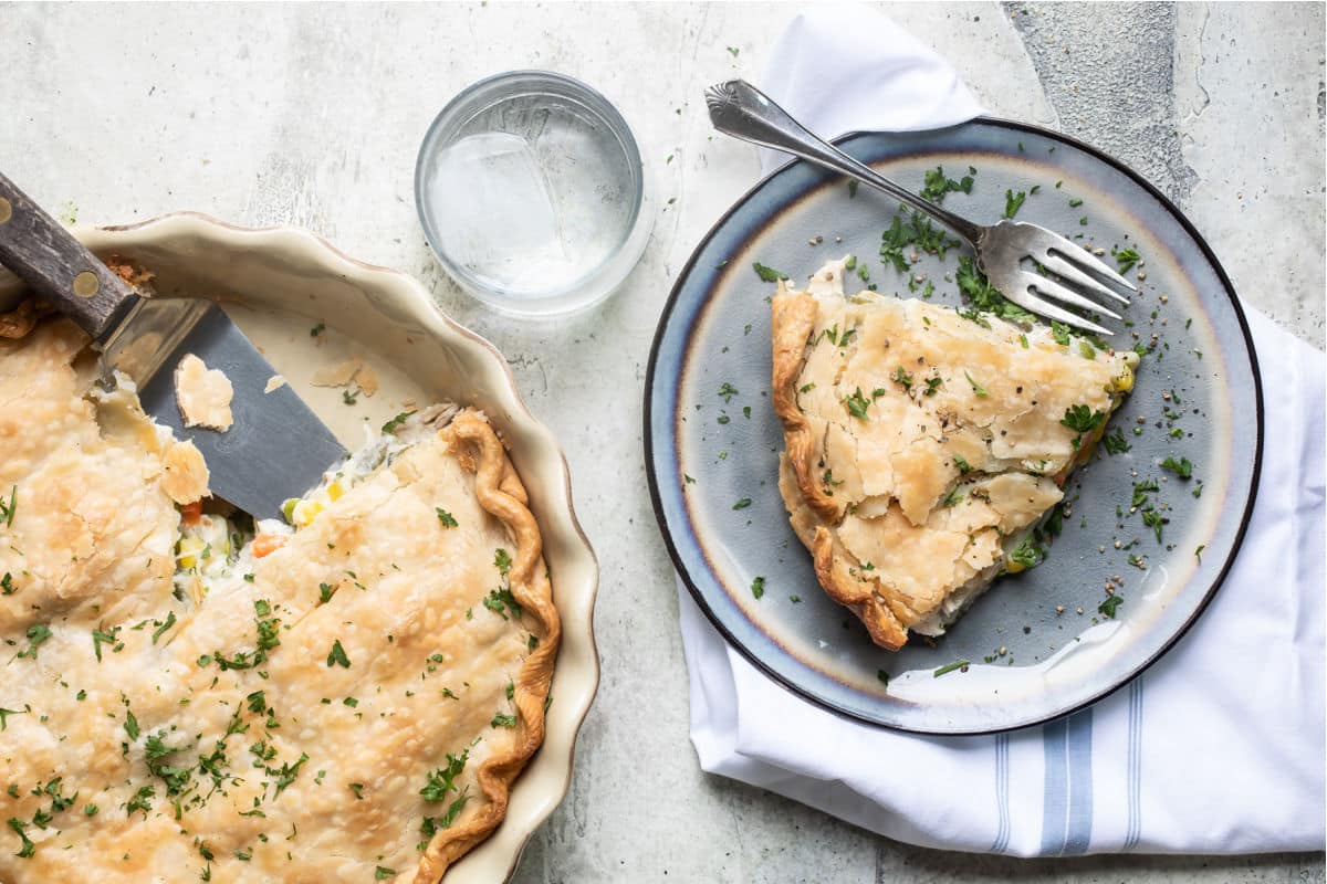 Turkey pot pie with a slice taken out and set on a plate.