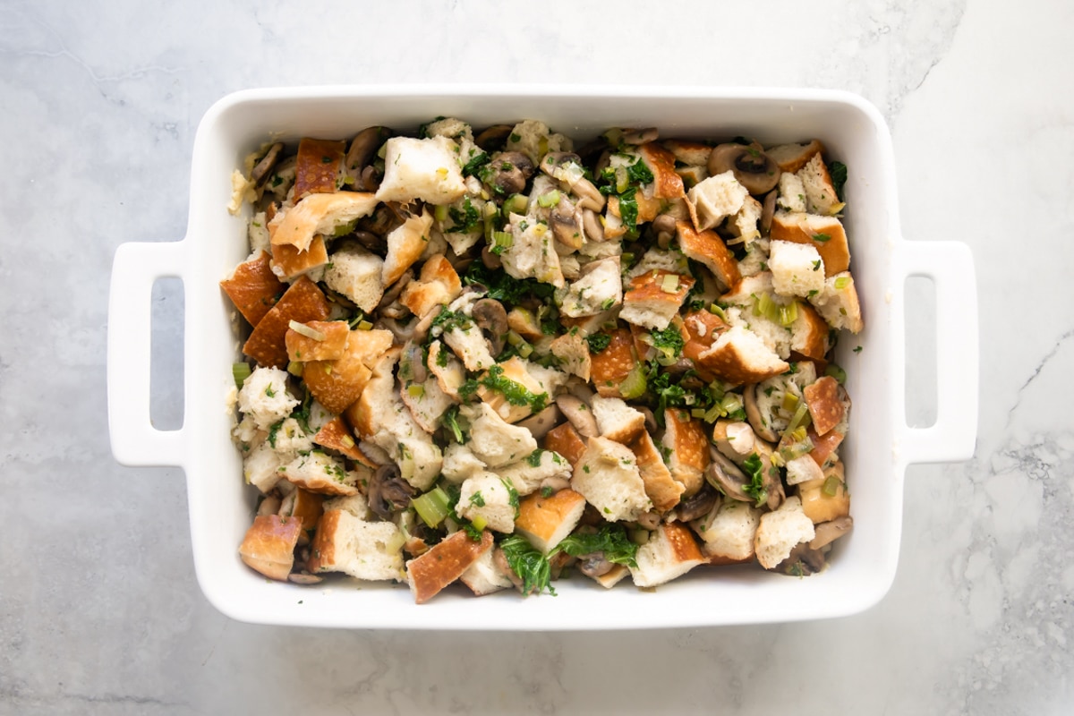 A casserole dish with vegan stuffing resting on a dish towel.