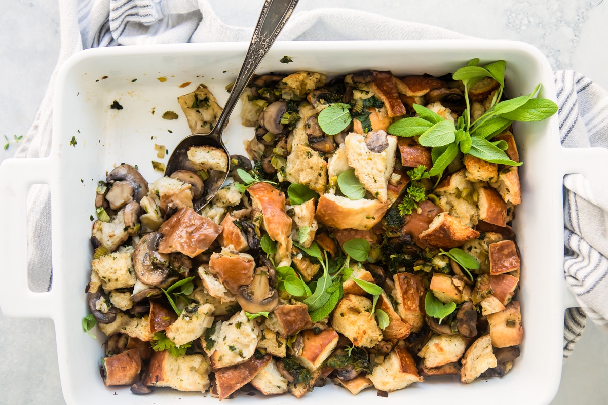 A casserole dish with vegan stuffing resting on a dish towel.