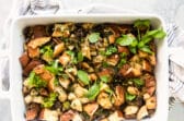 A casserole dish with vegan stuffing resting on a dish towel.