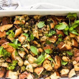 A casserole dish with vegan stuffing resting on a dish towel.