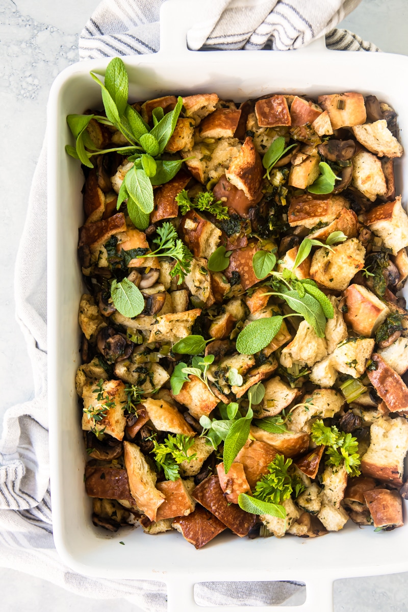 A casserole dish with vegan stuffing resting on a dish towel.