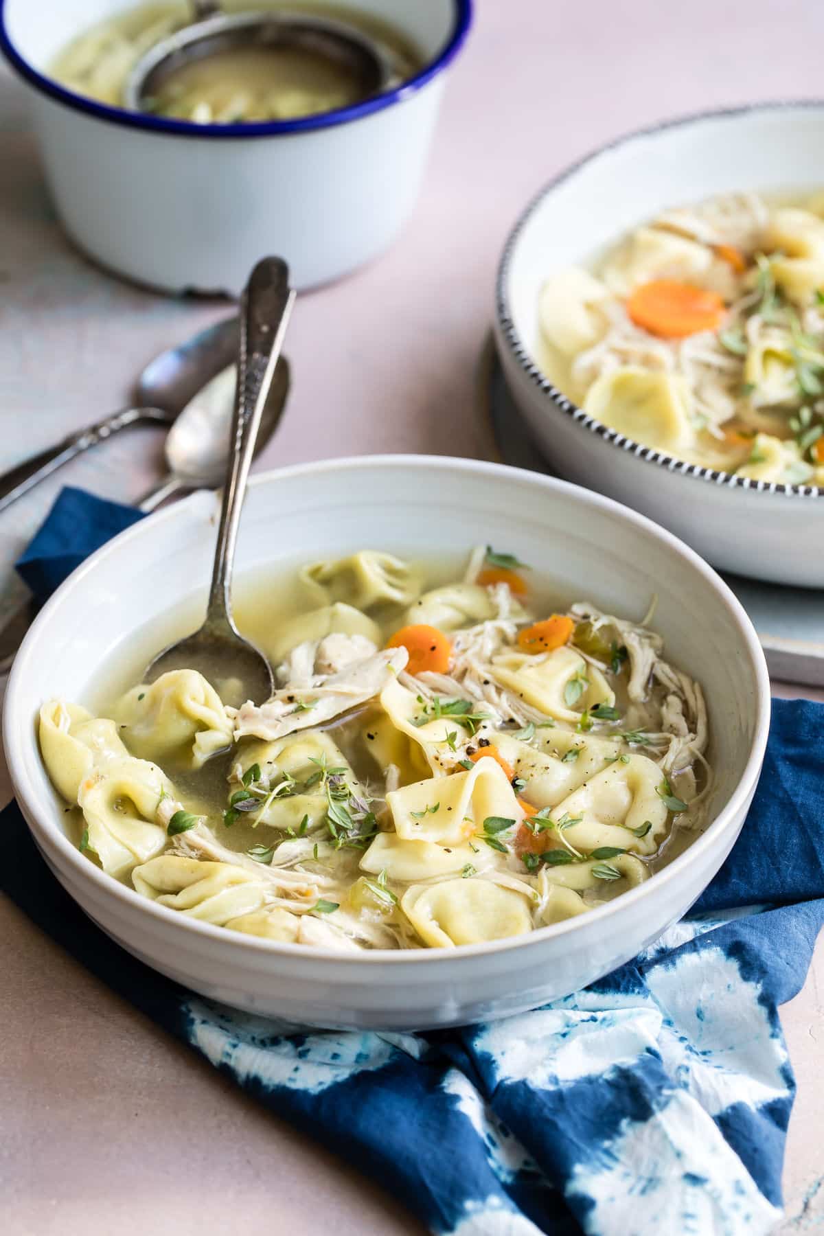 Slow cooker chicken tortellini soup in a white bowl.