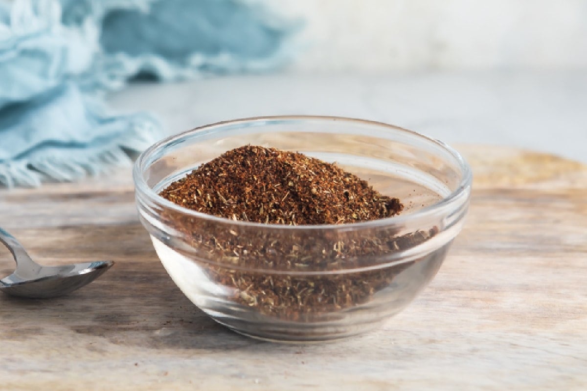 A bowl of homemade chili seasoning on a cutting board.