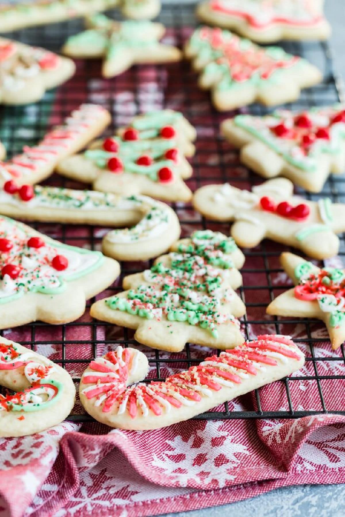 Frosted Christmas sugar cookies on a cooling rack.