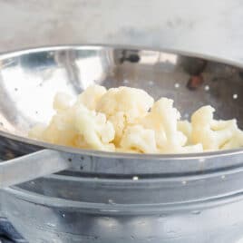 Blanched cauliflower in a colander.