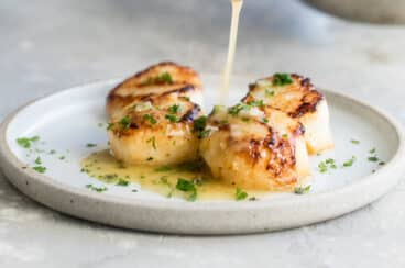 Lemon garlic butter sauce drizzled over seared scallops.