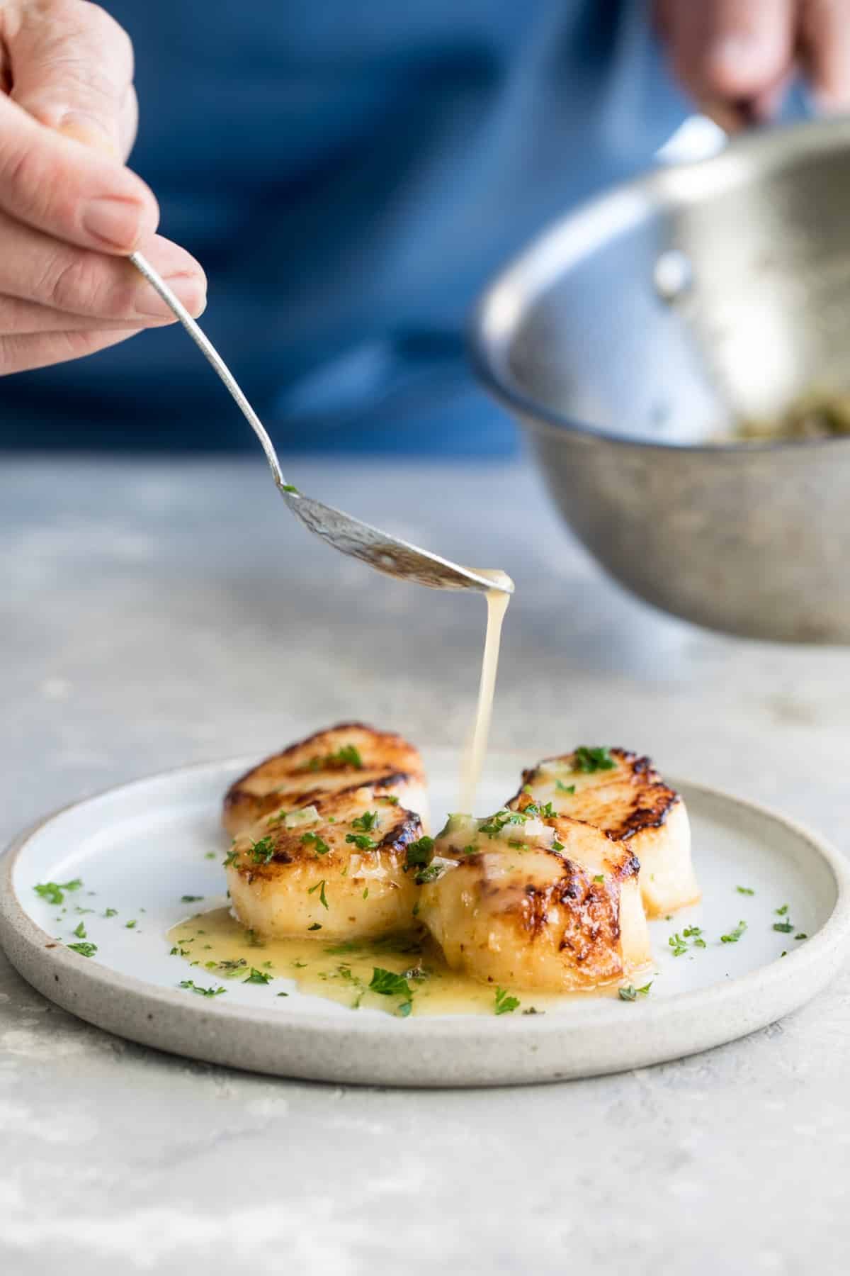 Lemon garlic butter sauce drizzled over seared scallops.