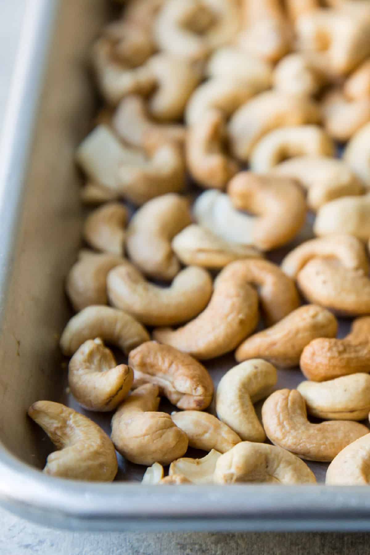 Roasted cashews on a baking sheet.