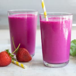 2 glasses of beet smoothie with straws.