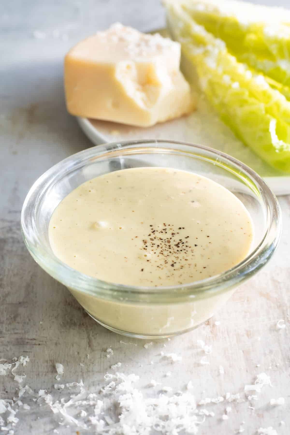 Caesar dressing in a clear bowl on a countertop.