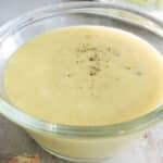 Coleslaw dressing in a clear bowl on a countertop.