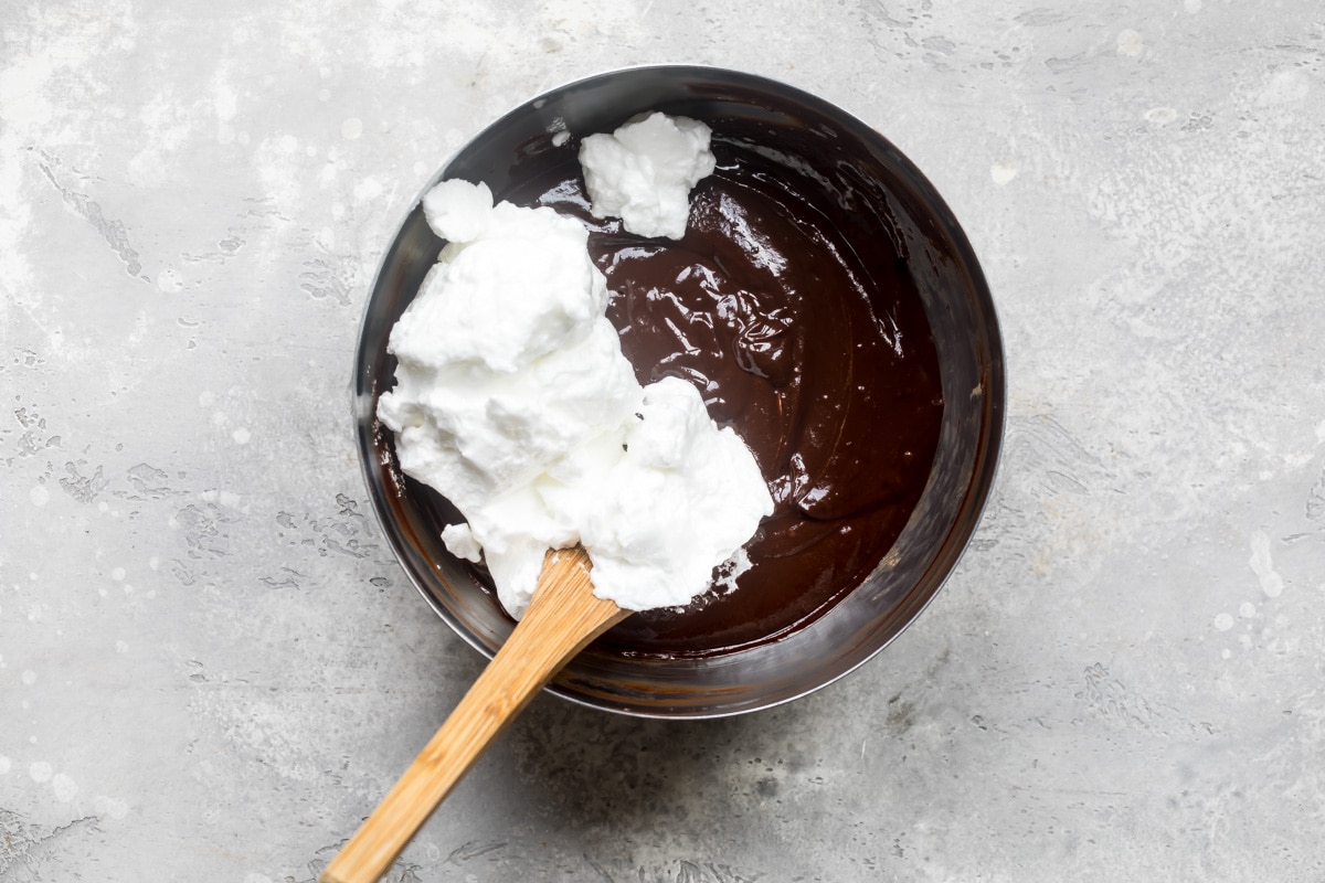 Flourless chocolate glaze ingredients being mixed together in a silver bowl.