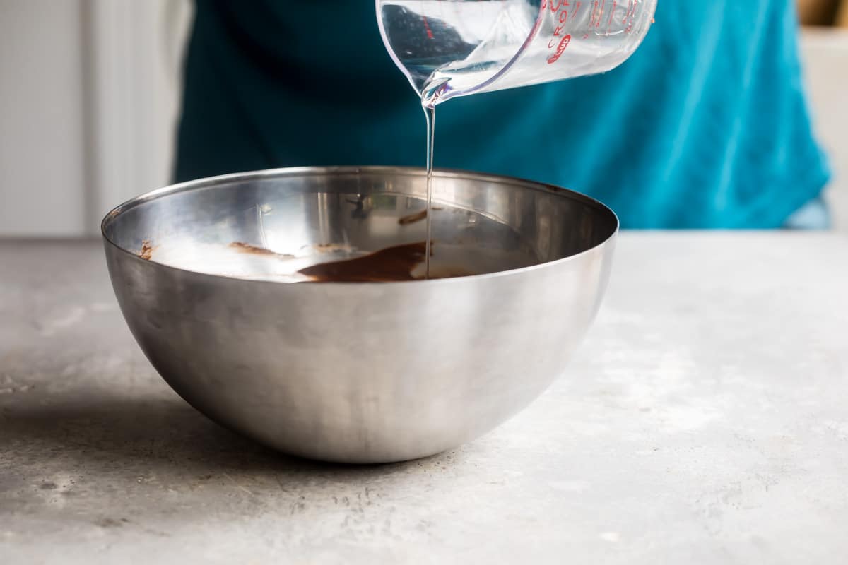 Corn syrup being poured into chocolate glaze.