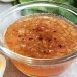 Hot bacon dressing in a clear bowl on a countertop.