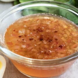 Hot bacon dressing in a clear bowl on a countertop.