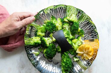 A steamer basket full of broccoli.