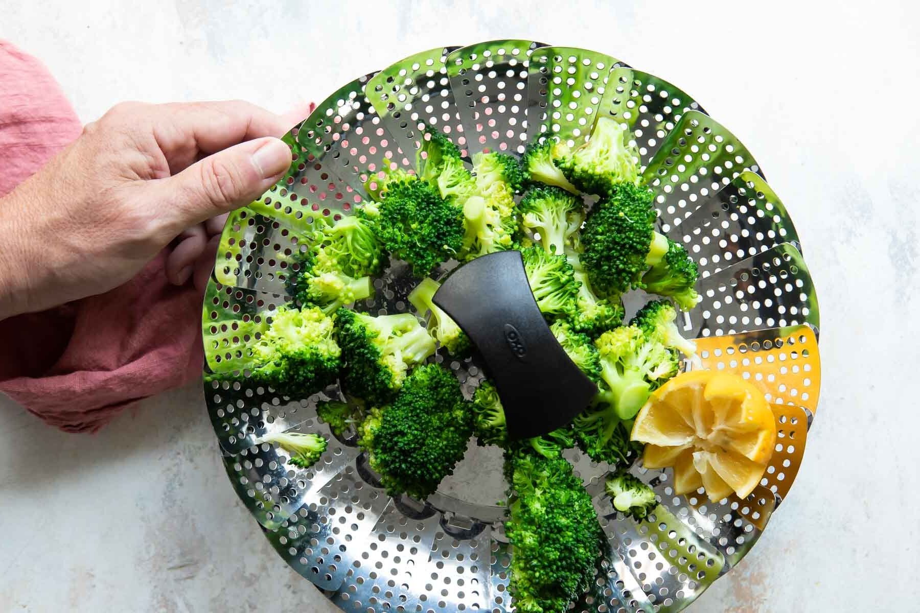 A steamer basket full of broccoli.