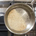 Sesame seeds toasting in a skillet.