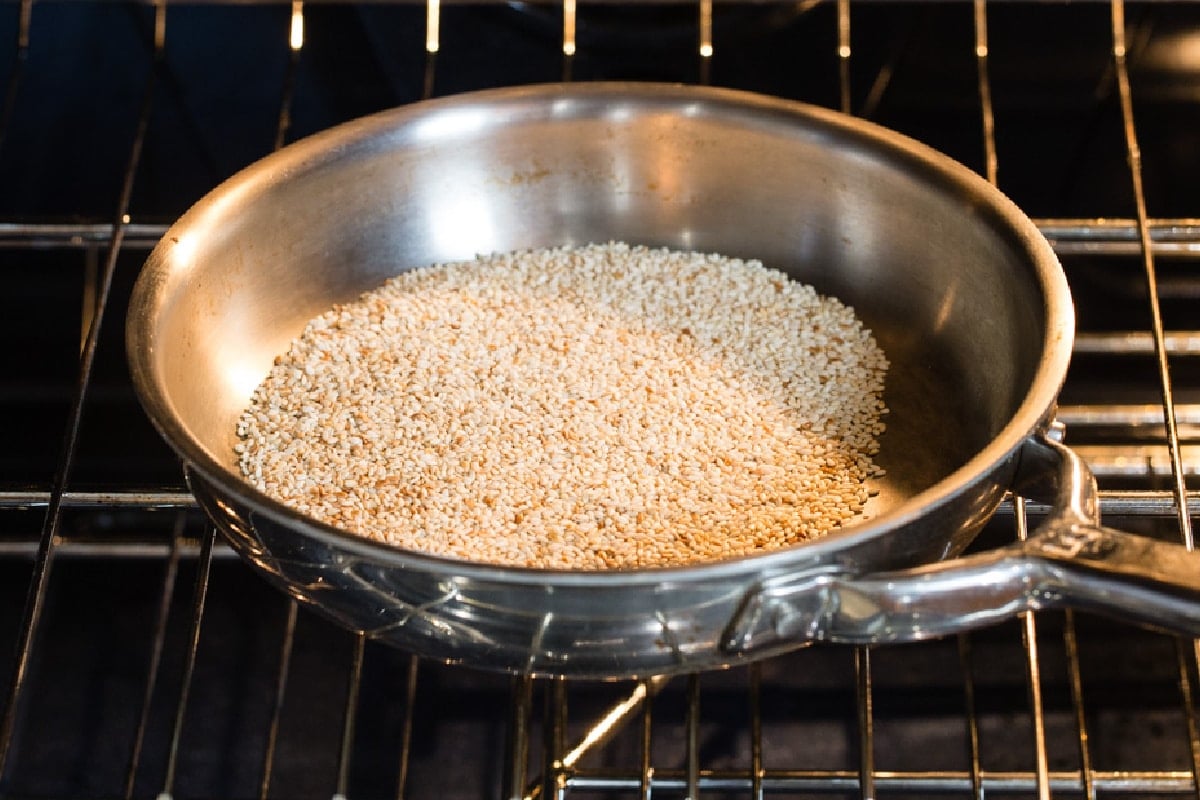 Sesame seeds toasting in a skillet.