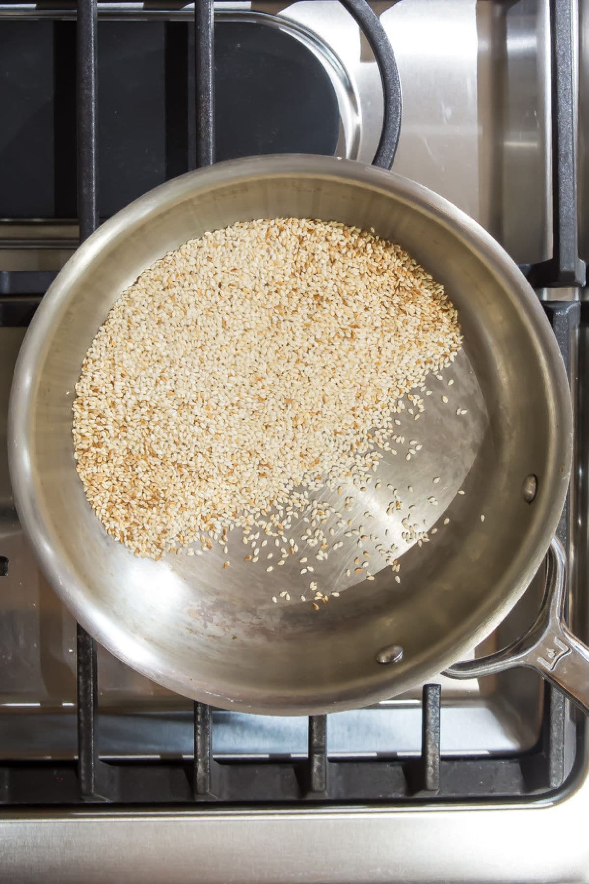 Sesame seeds toasting in a skillet.