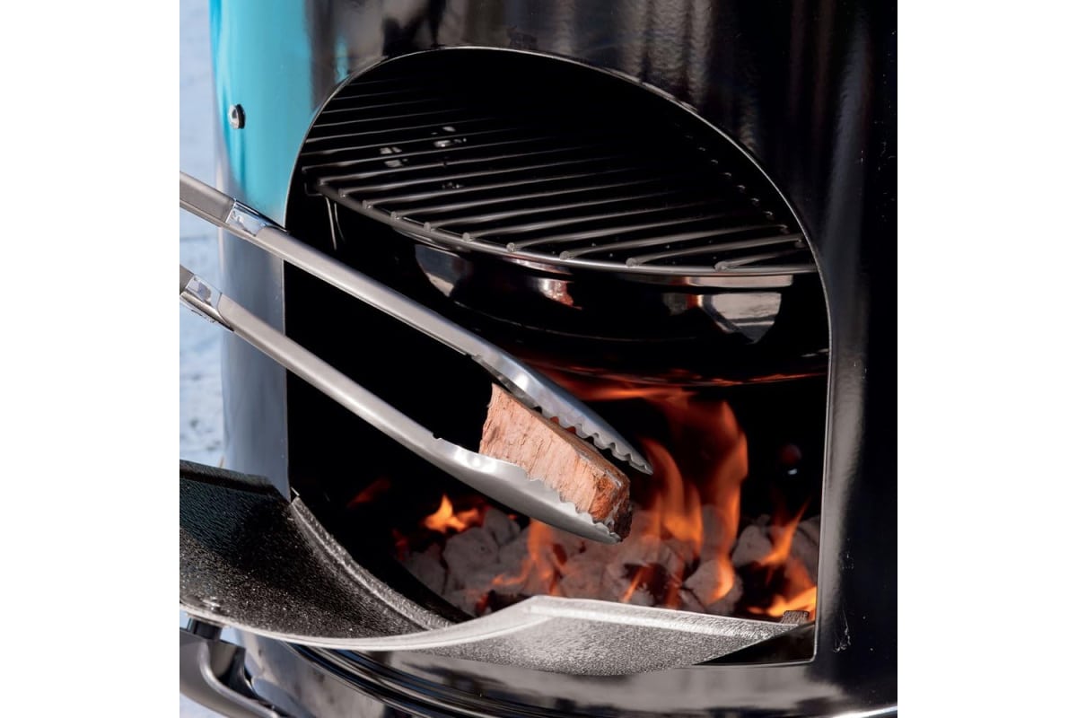 Adding hardwood to a smoker.