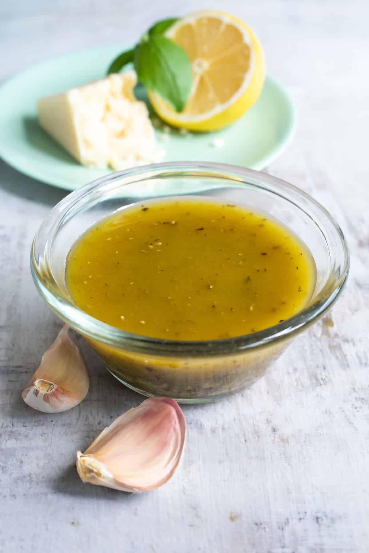 Italian dressing in a clear bowl on a countertop.