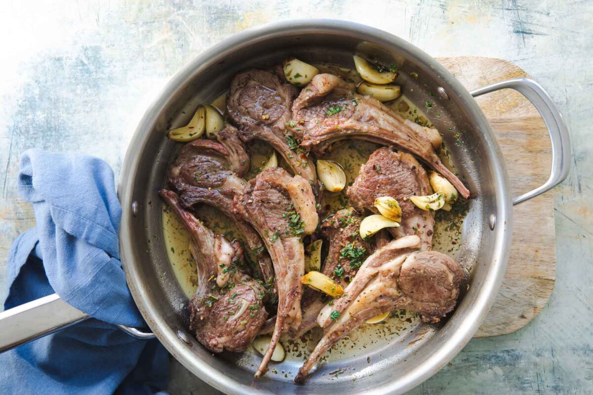 A pan of lamp chops garnished with garlic.