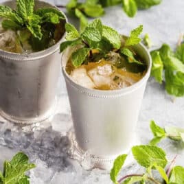 Two mint juleps in silver cups.