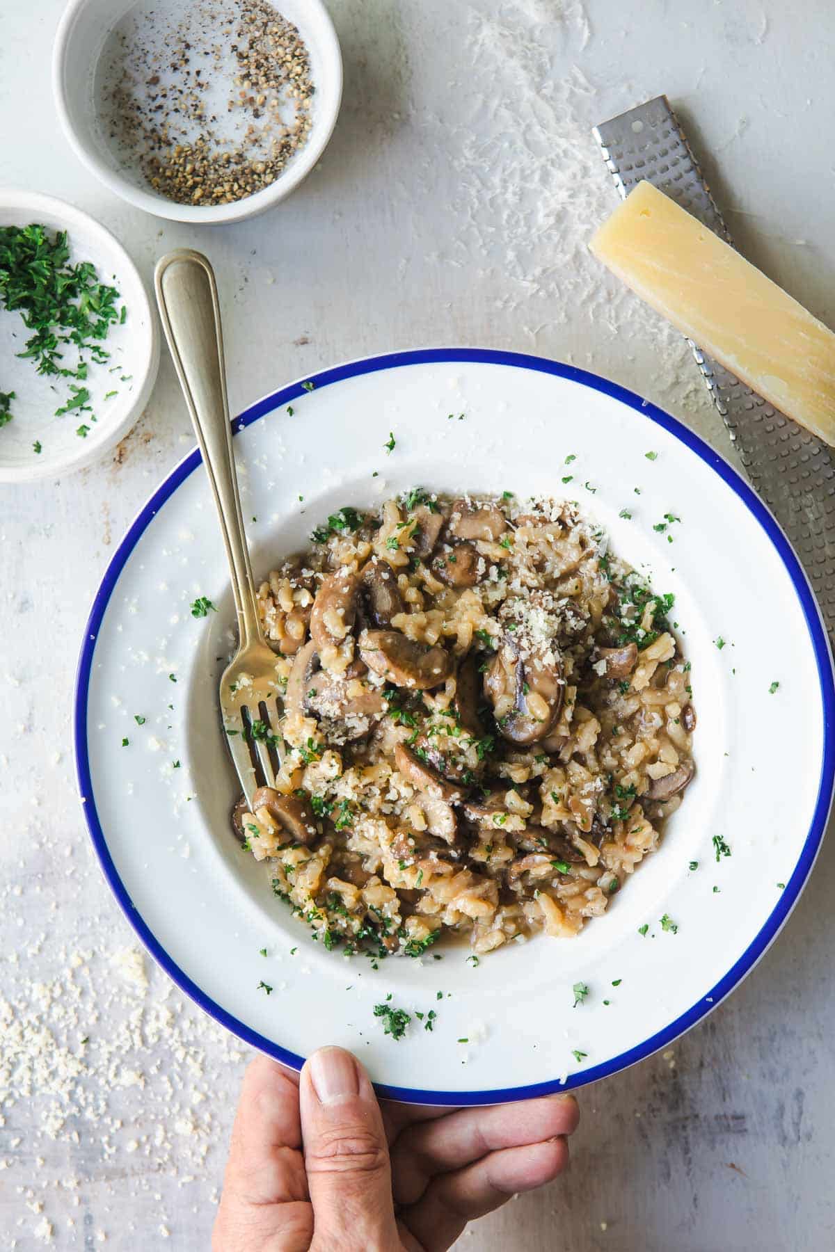 A white bowl full of mushroom risotto.