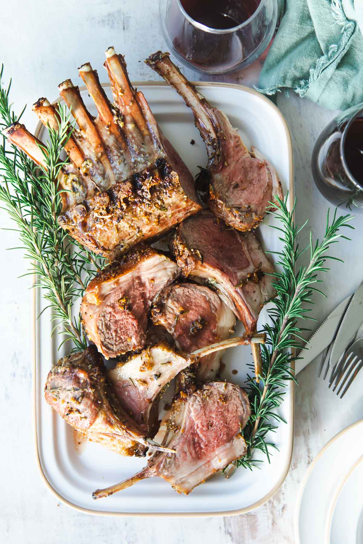 Roast rack of lamb on a white platter.