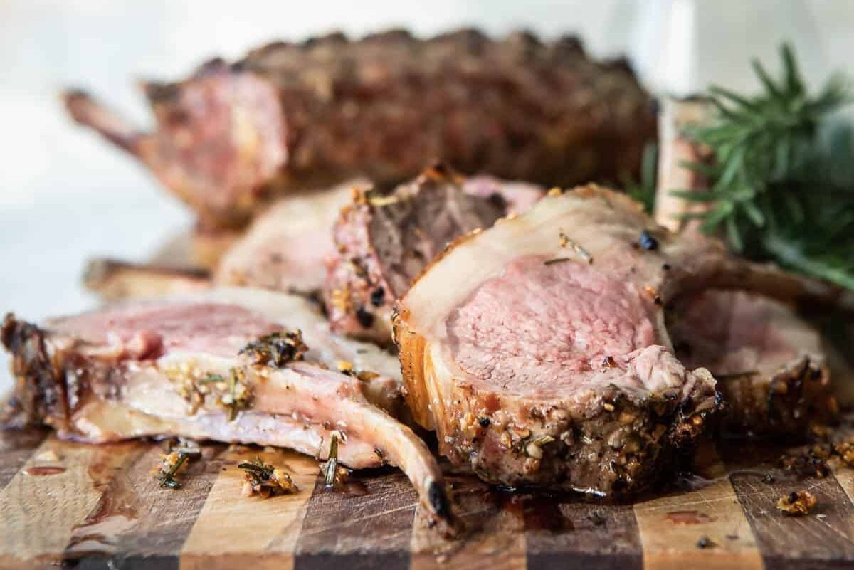 Roast rack of lamb on a cutting board.