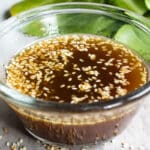 Sesame dressing in a clear bowl on a countertop.