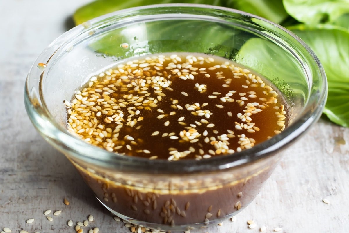 Sesame dressing in a clear bowl on a countertop.