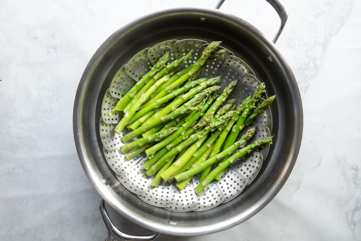 Steamed asparagus in a steamer basket.