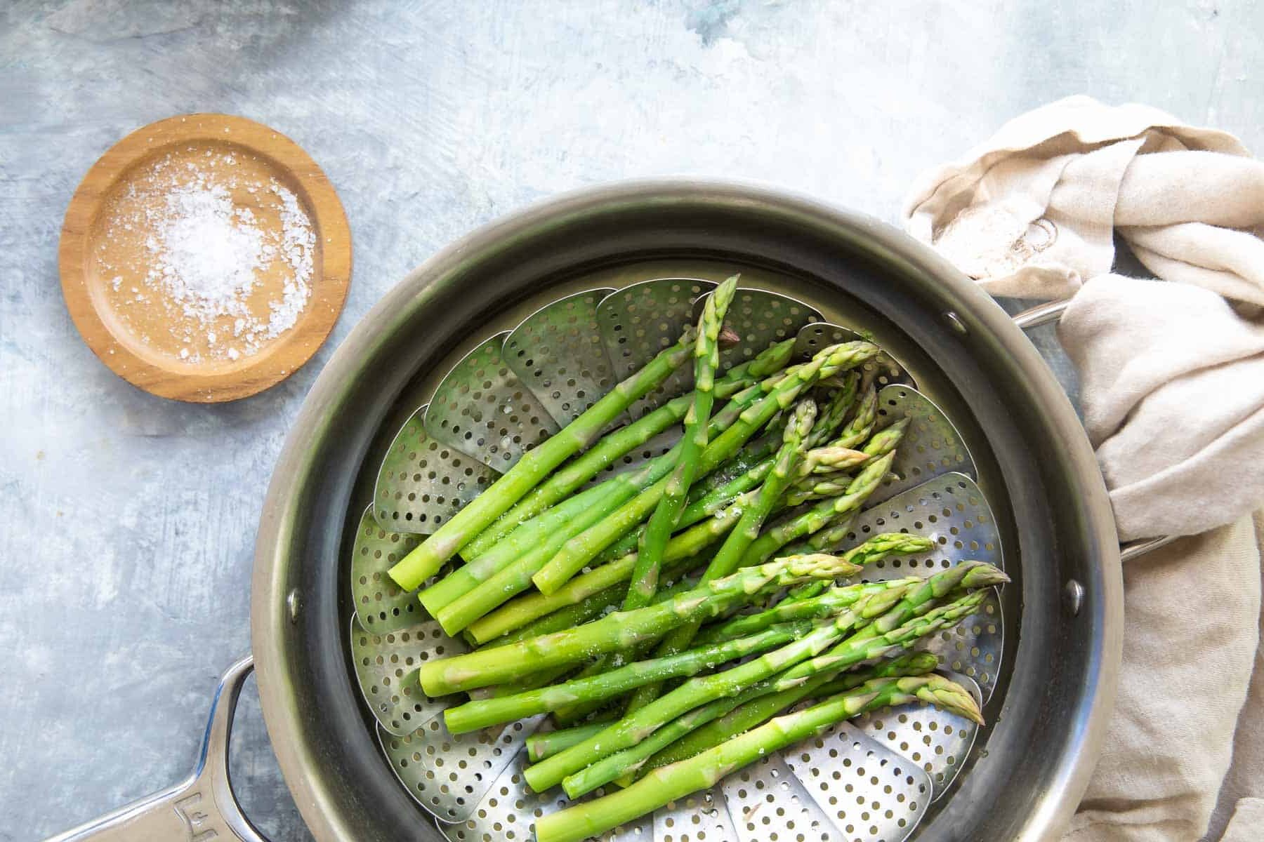 Steamed asparagus in a steamer basket.