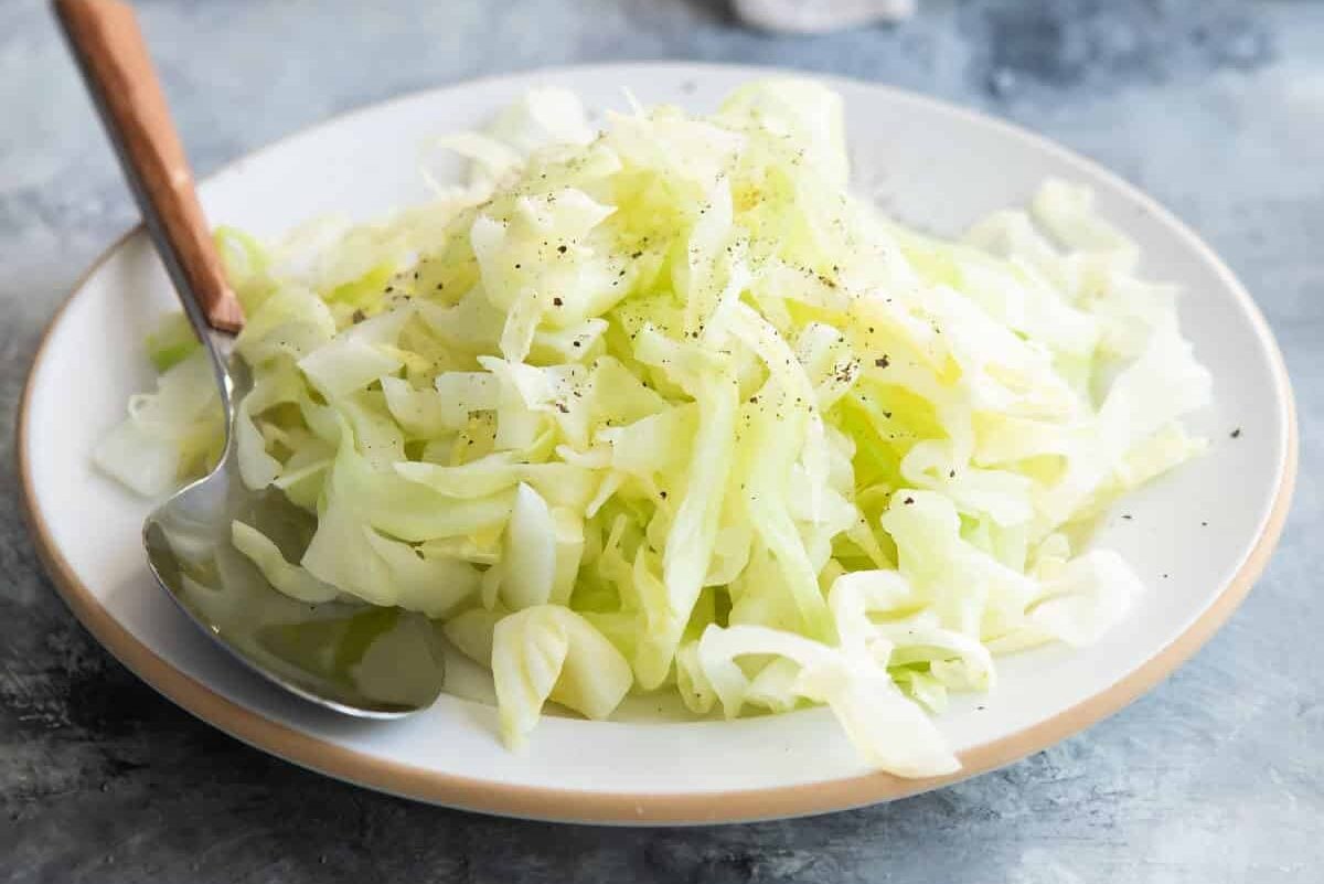 Steamed cabbage on a white plate.