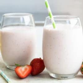 Two strawberry banana smoothies in glasses.
