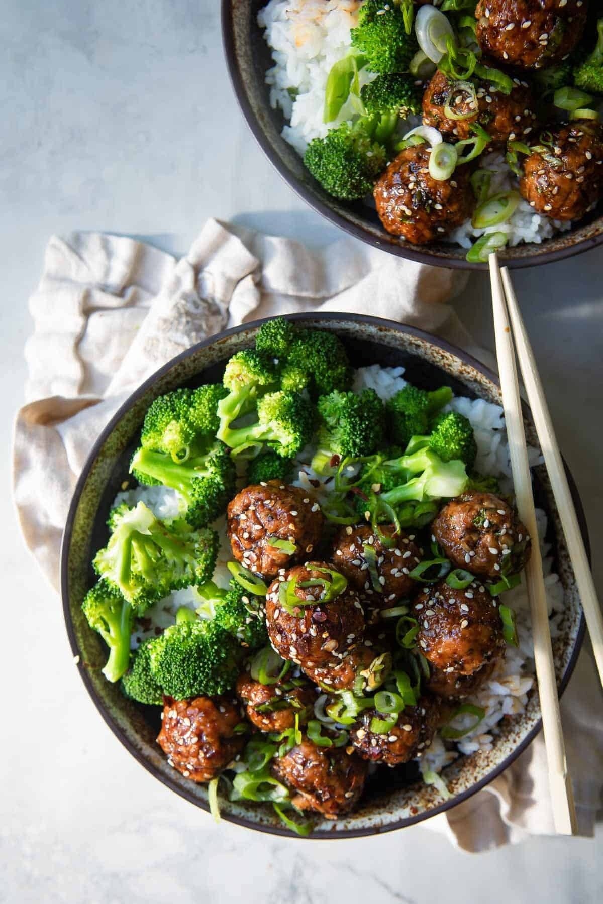 A bowl of Teriyaki meatballs over rice with broccoli.