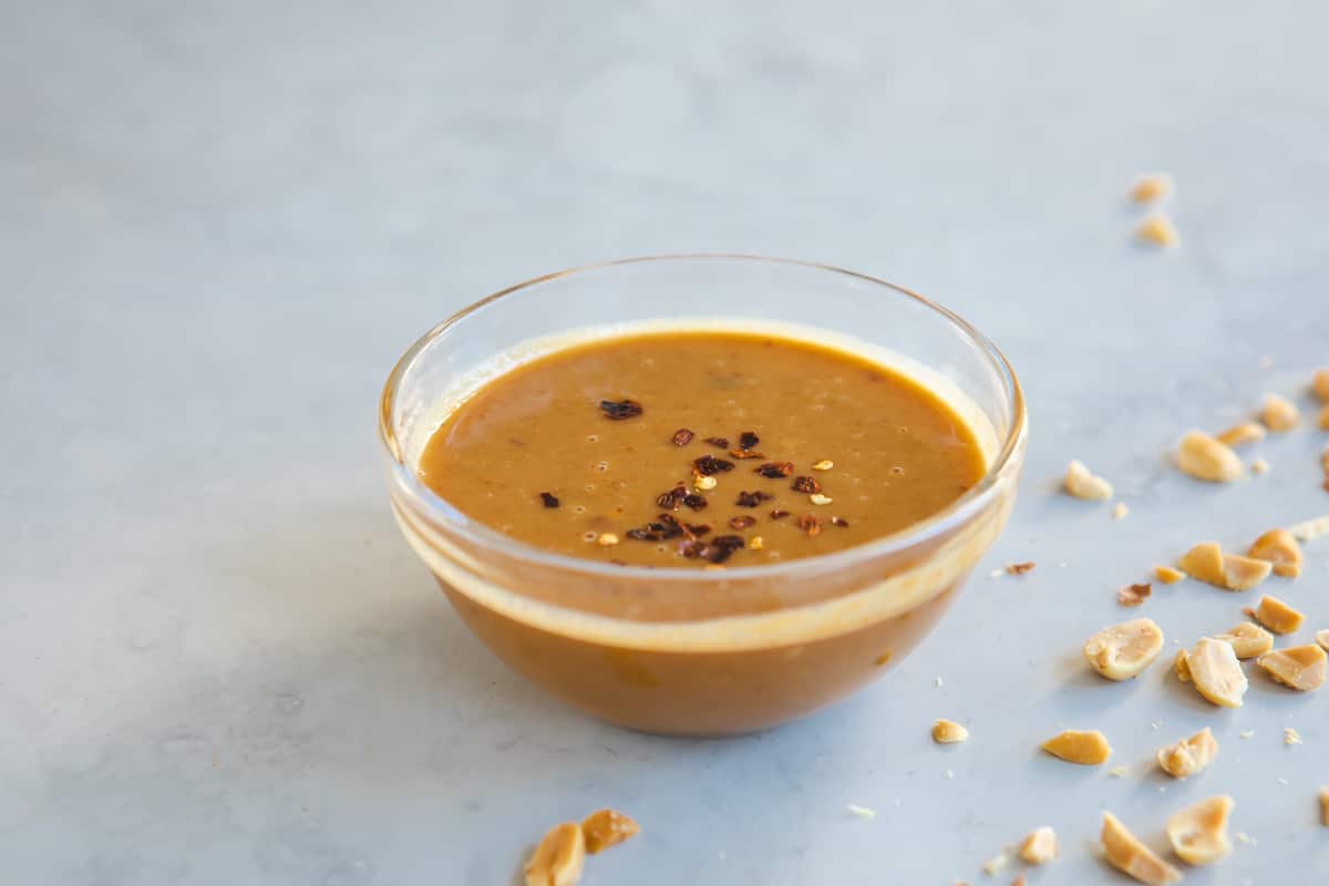 Thai peanut dressing in a small clear bowl.