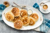 A platter of vegan pancakes with maple syrup on top.