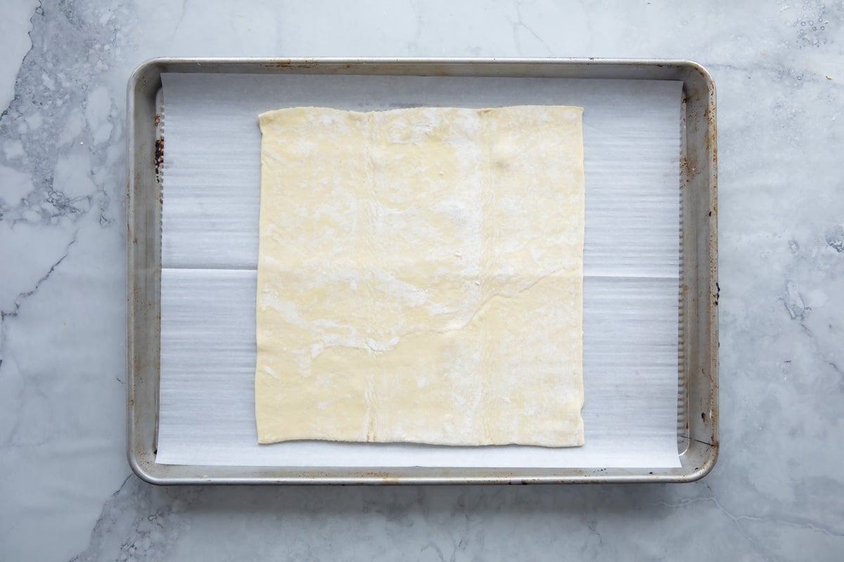 A piece of puff pastry on a baking sheet.