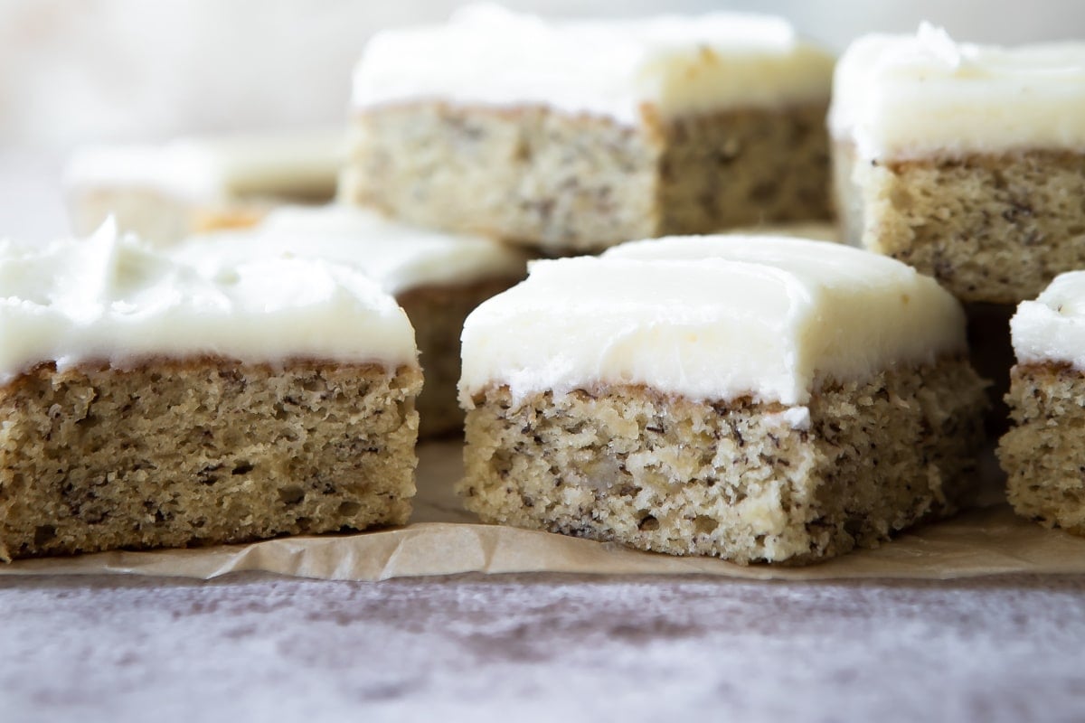A pile of banana bars on a piece of parchment paper.