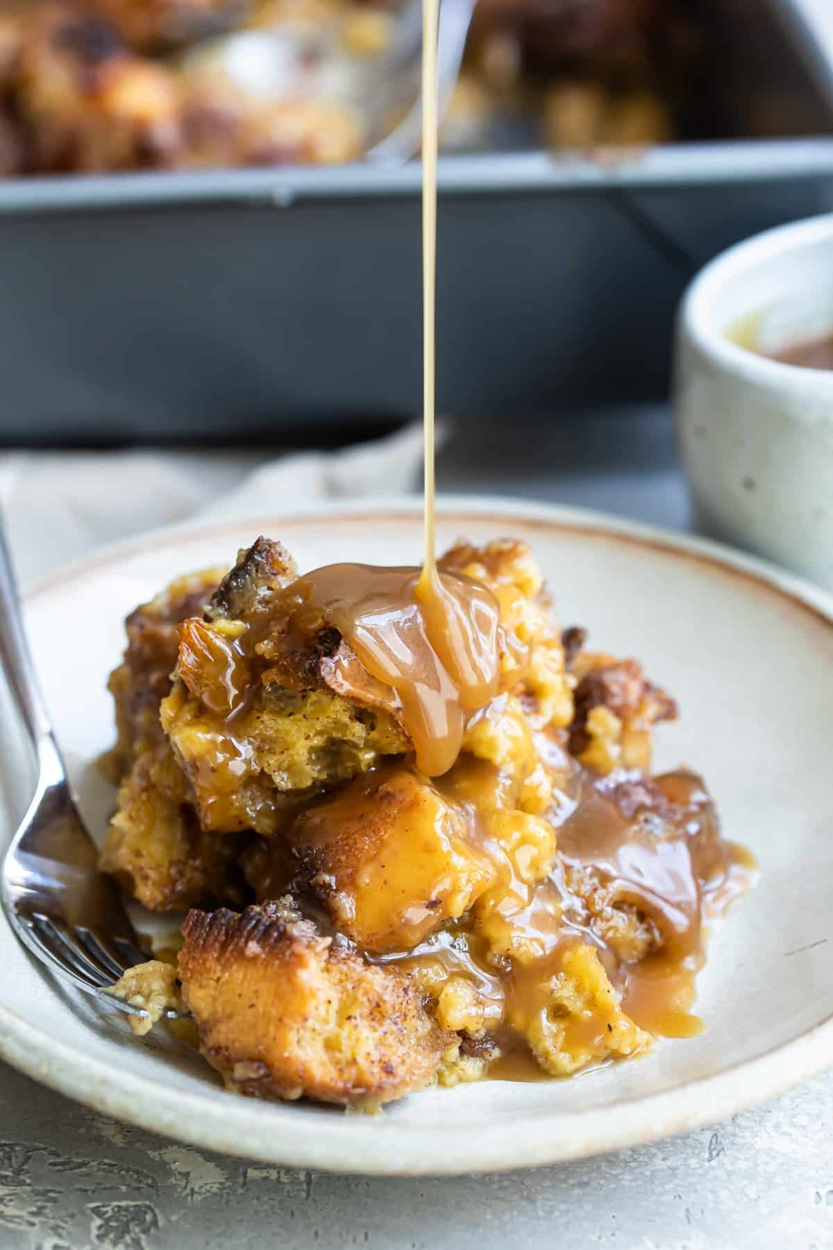 A plate of bread pudding with a fork resting on it.
